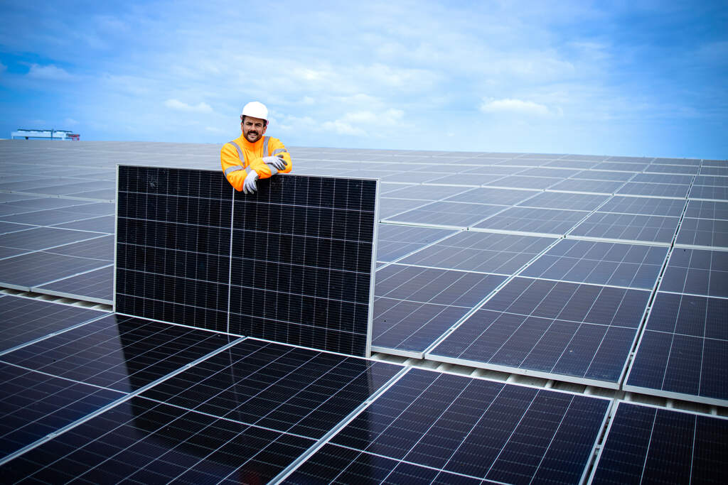 Placas de energia solar com homem em cima